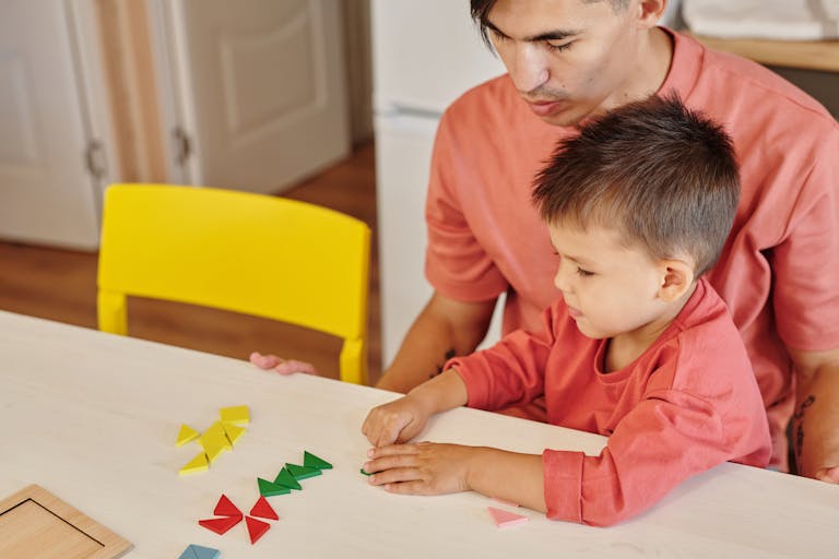 Father and son bonding over educational shapes at home. Bright and colorful scene.